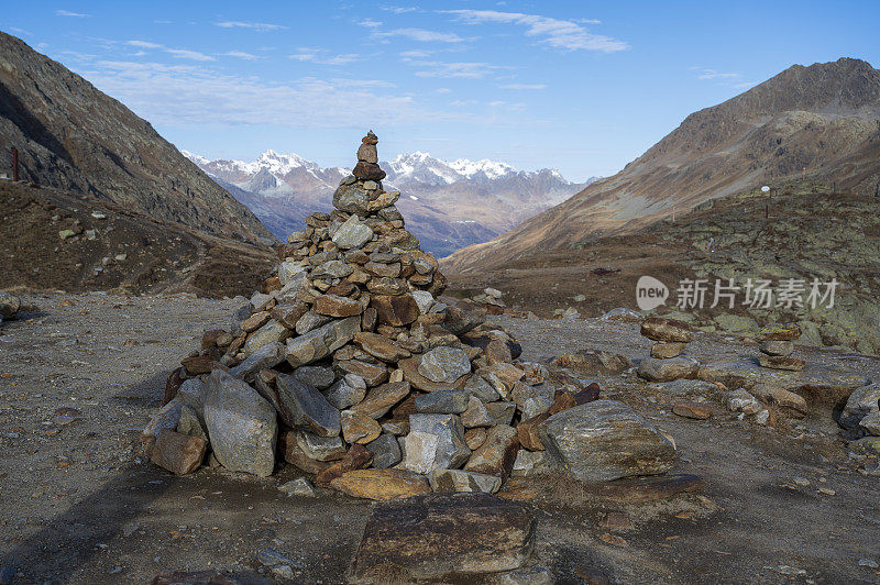 Stacked pile of stones high in the mountains overlooking the valley and the ridge of the mountains.